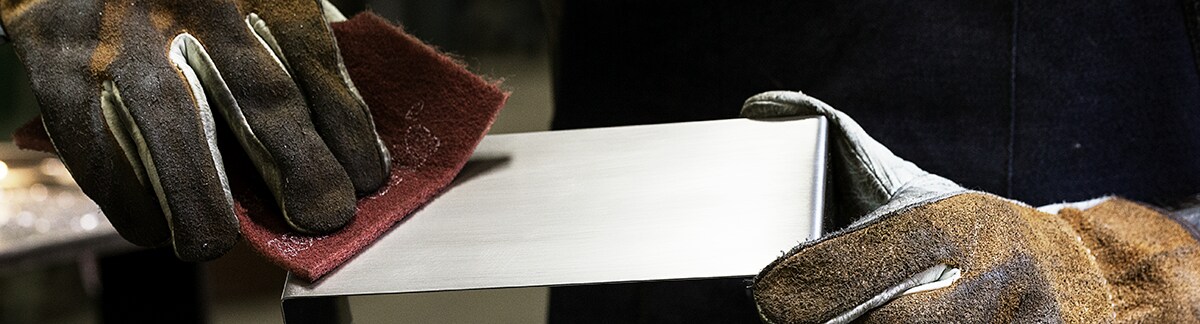 image of hand pad being used on metal
