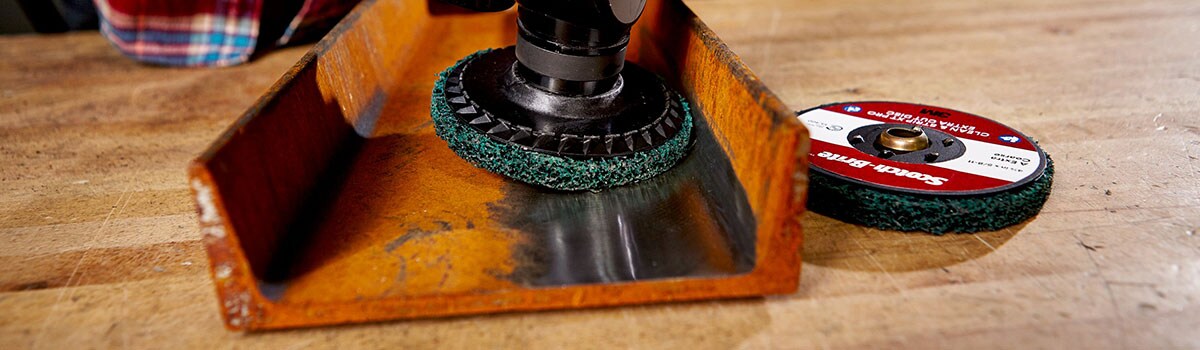 Metal surface preparation using a non-woven abrasive
